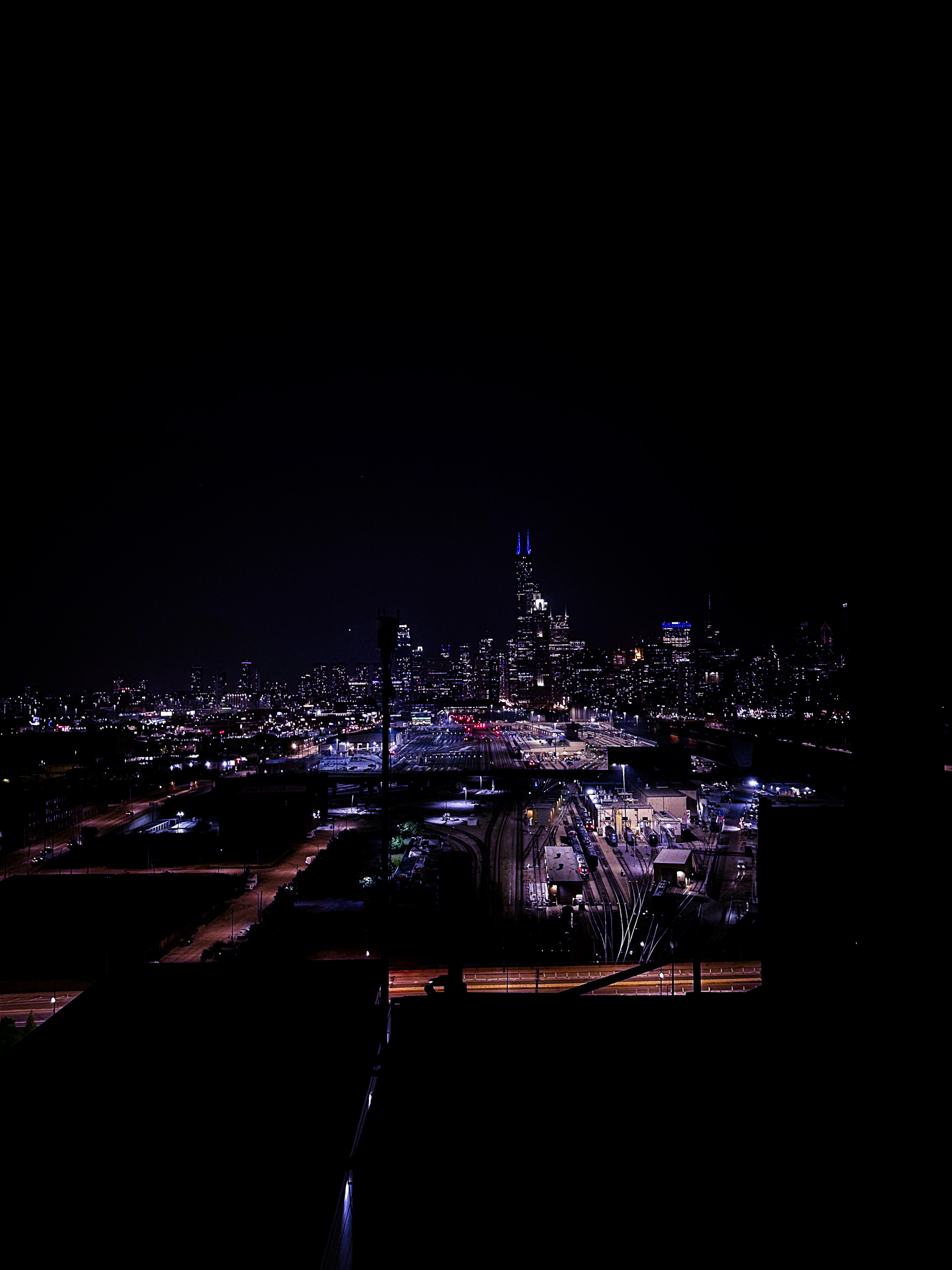 Chicago skyline at night with purple light in the distance
